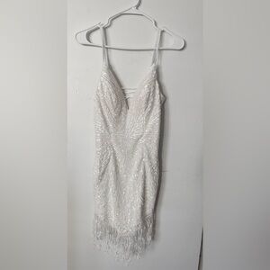 White, sequin, flapper-style dress.